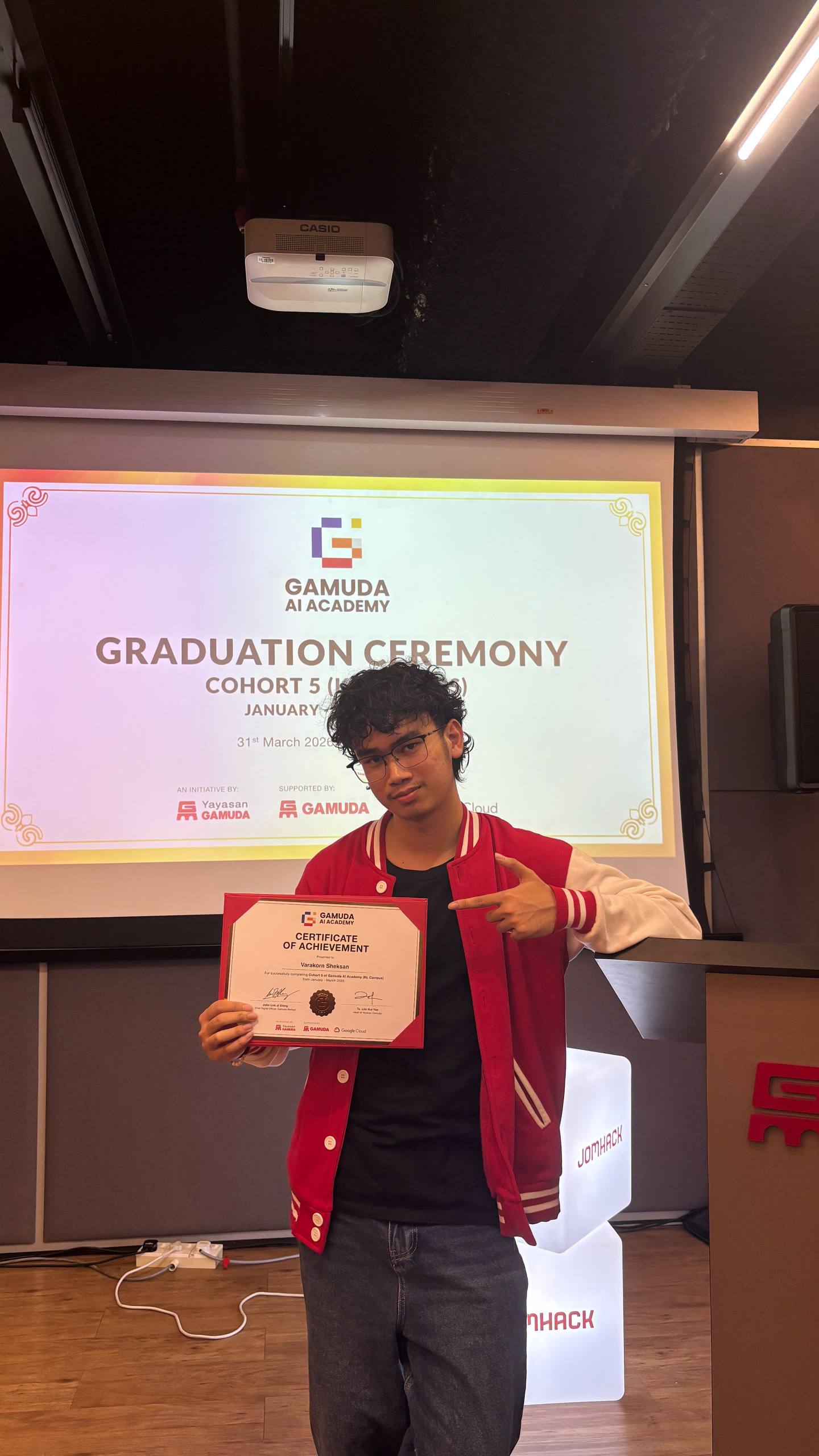 Varakorn holding his Gamuda AI Academy certificate at the graduation ceremony